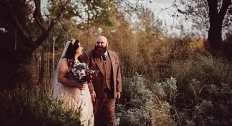 Bride and groom walking in woodland