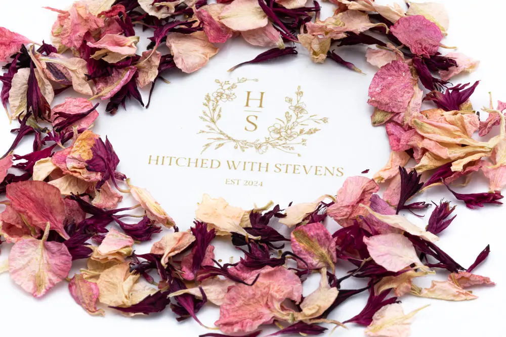 Red and pink flower leaf confetti in a circle around a logo