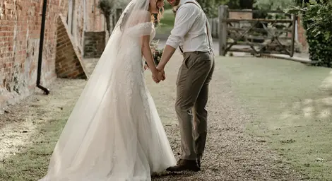 Bride and groom laughing together in courtyard