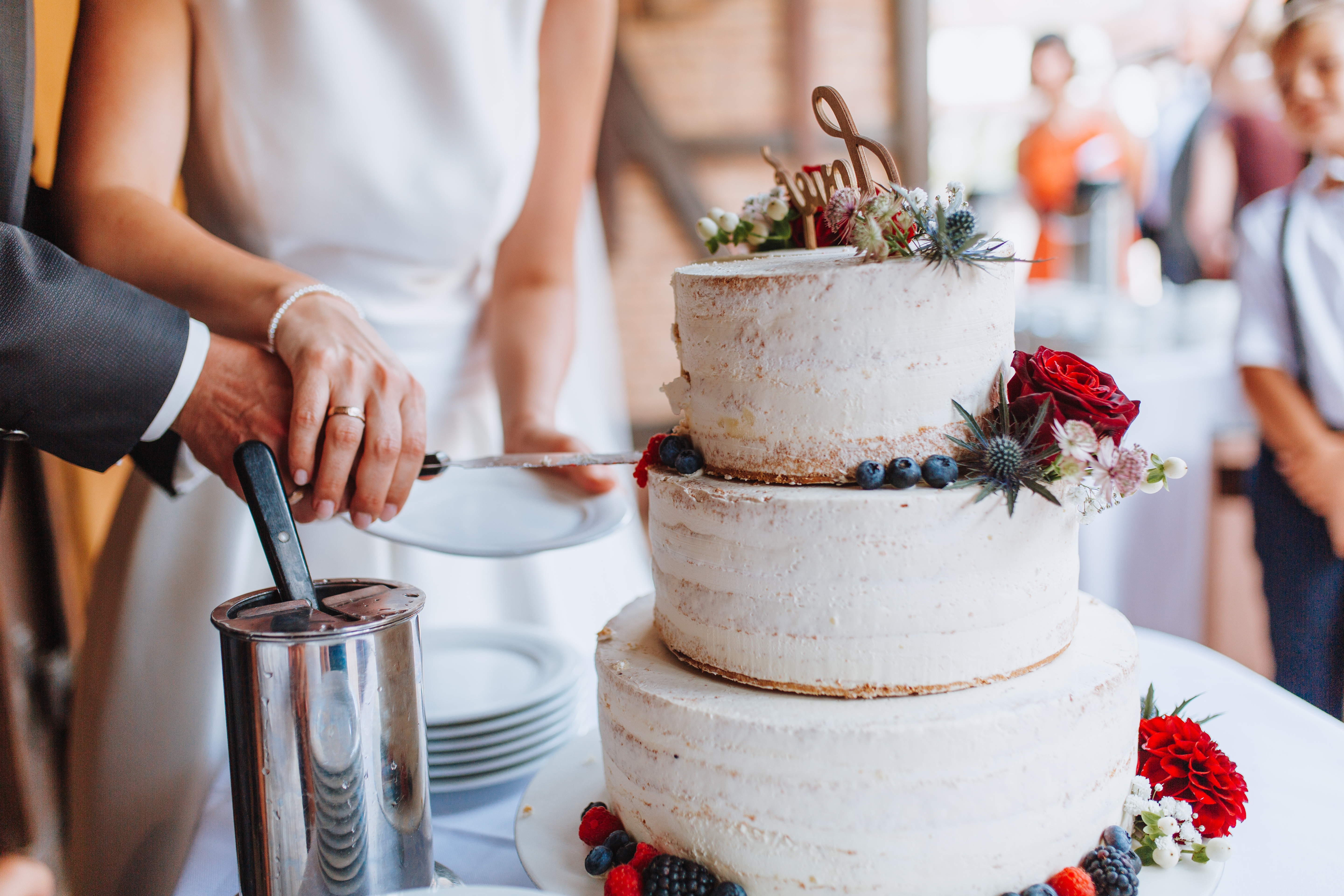 Bride and groom cutting through the second later of their wedding cake. 