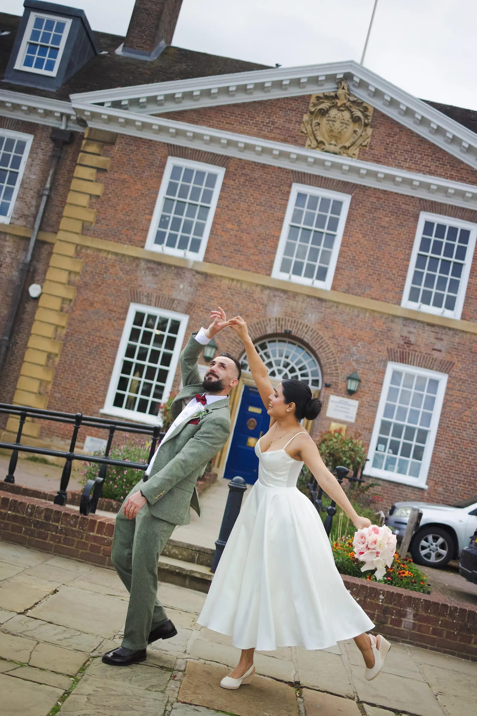 Bride and groom twirling in front of Bury Register office