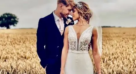 Bride and groom standing in corn field