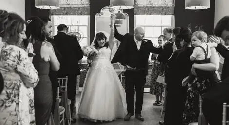 Black and white photo bride and groom celebrating in Bury Register Office
