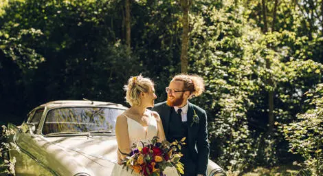 Bride and groom sitting on car looking at each other photographed by Chloe Lee Photo
