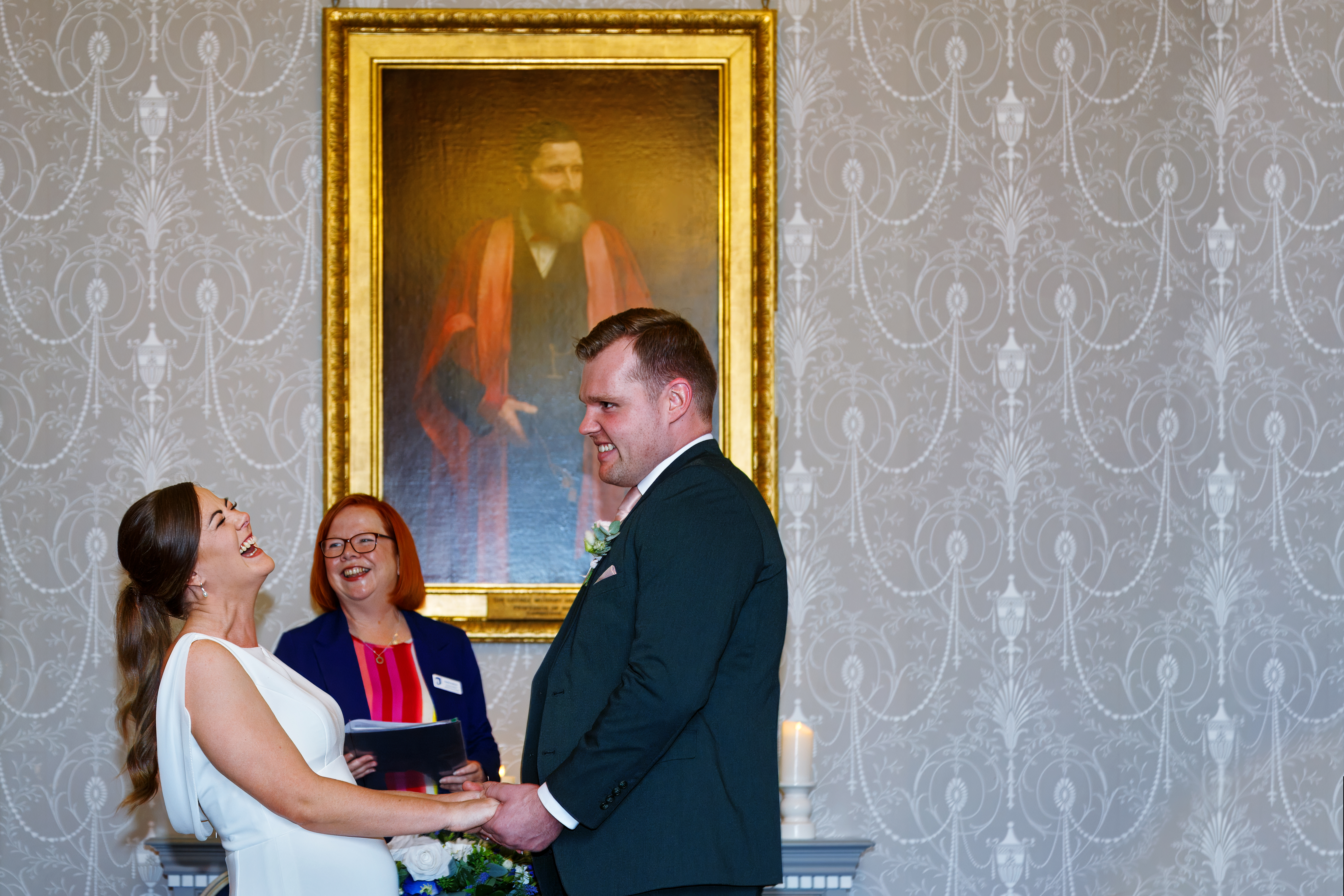 Couple and Registrar laughing during their wedding ceremony at the Mayor's Parlour at Sudbury Town Hall