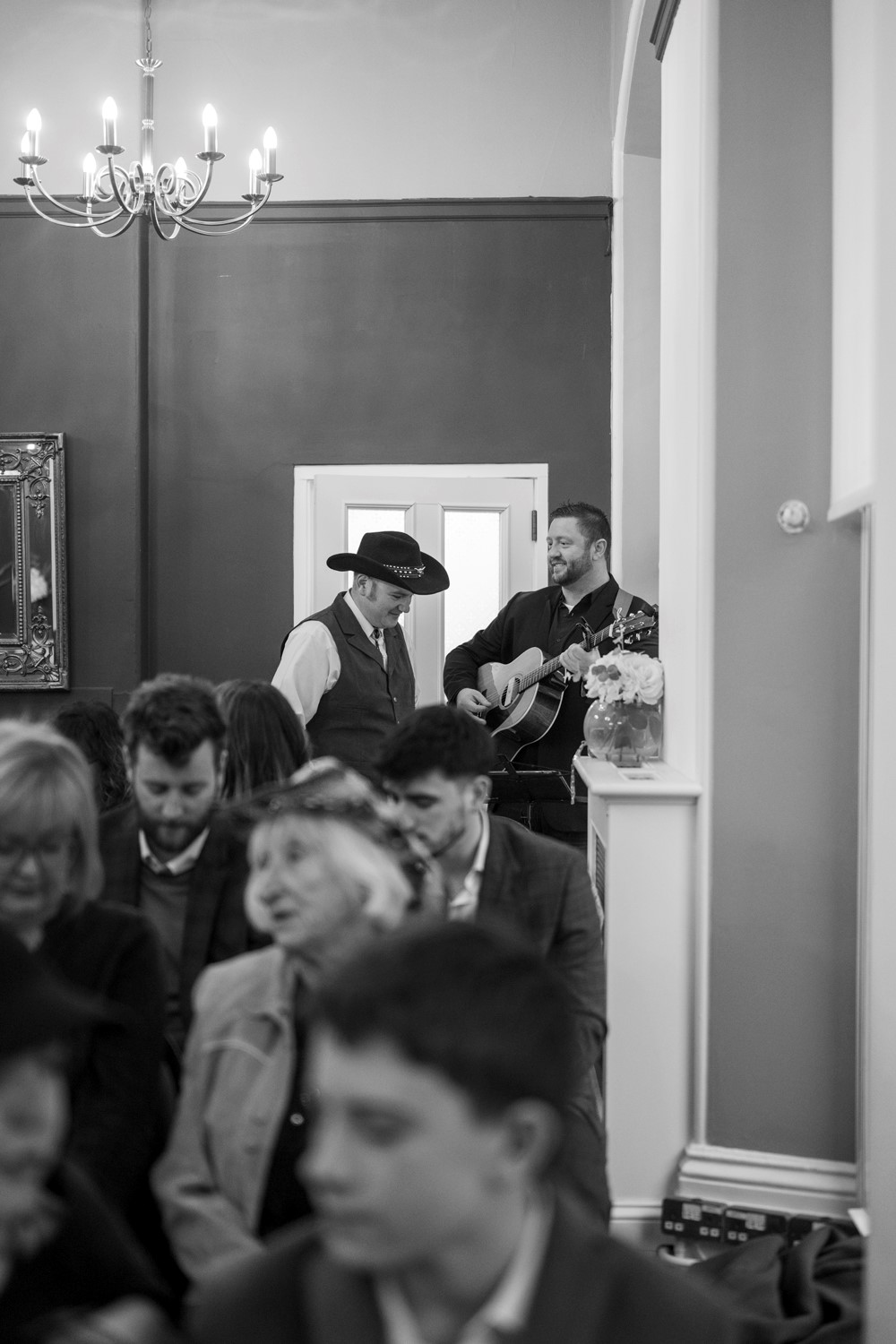 Wedding singer playing guitar at a register office wedding inspired by Texas groom wearing Stetson