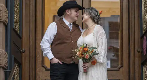 Bride and groom in cowboy attire outside Ipswich Town Hall