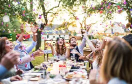 young couple celebrating their wedding in a garden with guests