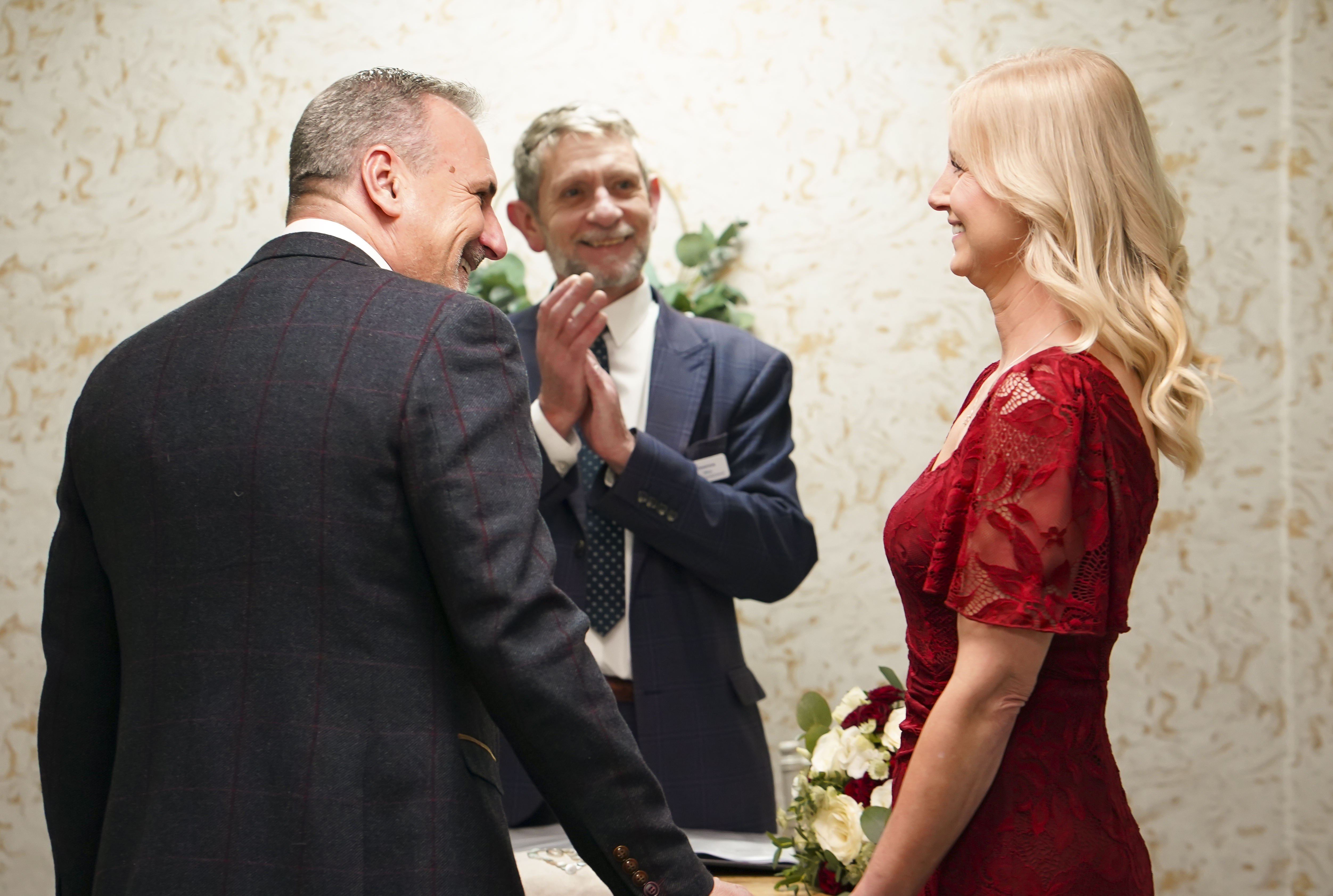 Couple smiling at each other while Registrar applauds