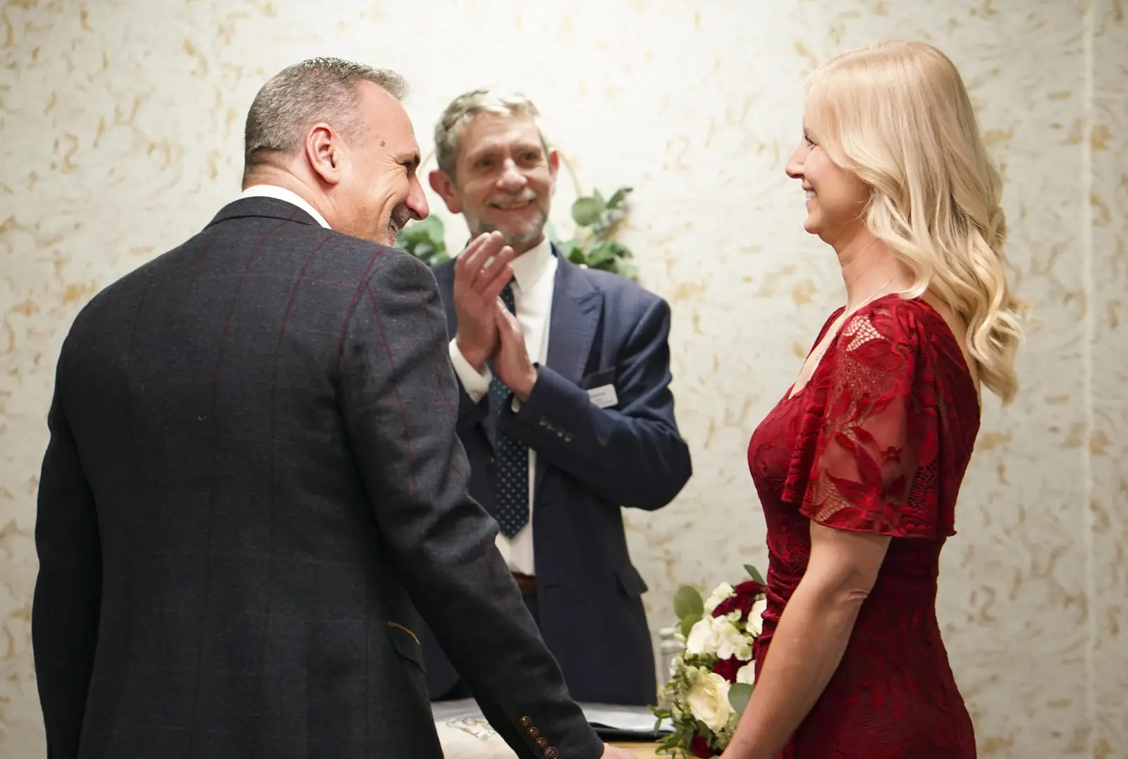 Couple smiling at each other while Registrar applauds