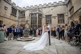 Bride and groom dancing in venue courtyard in front of their wedding guests.