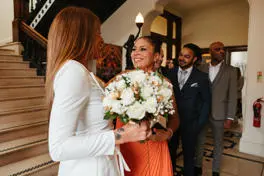 Bride holding flowers smiling with one of her guests