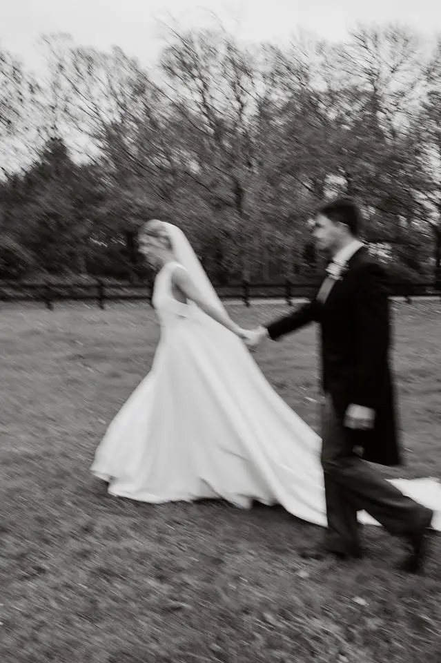 Bride and groom in black and white walking in parkland