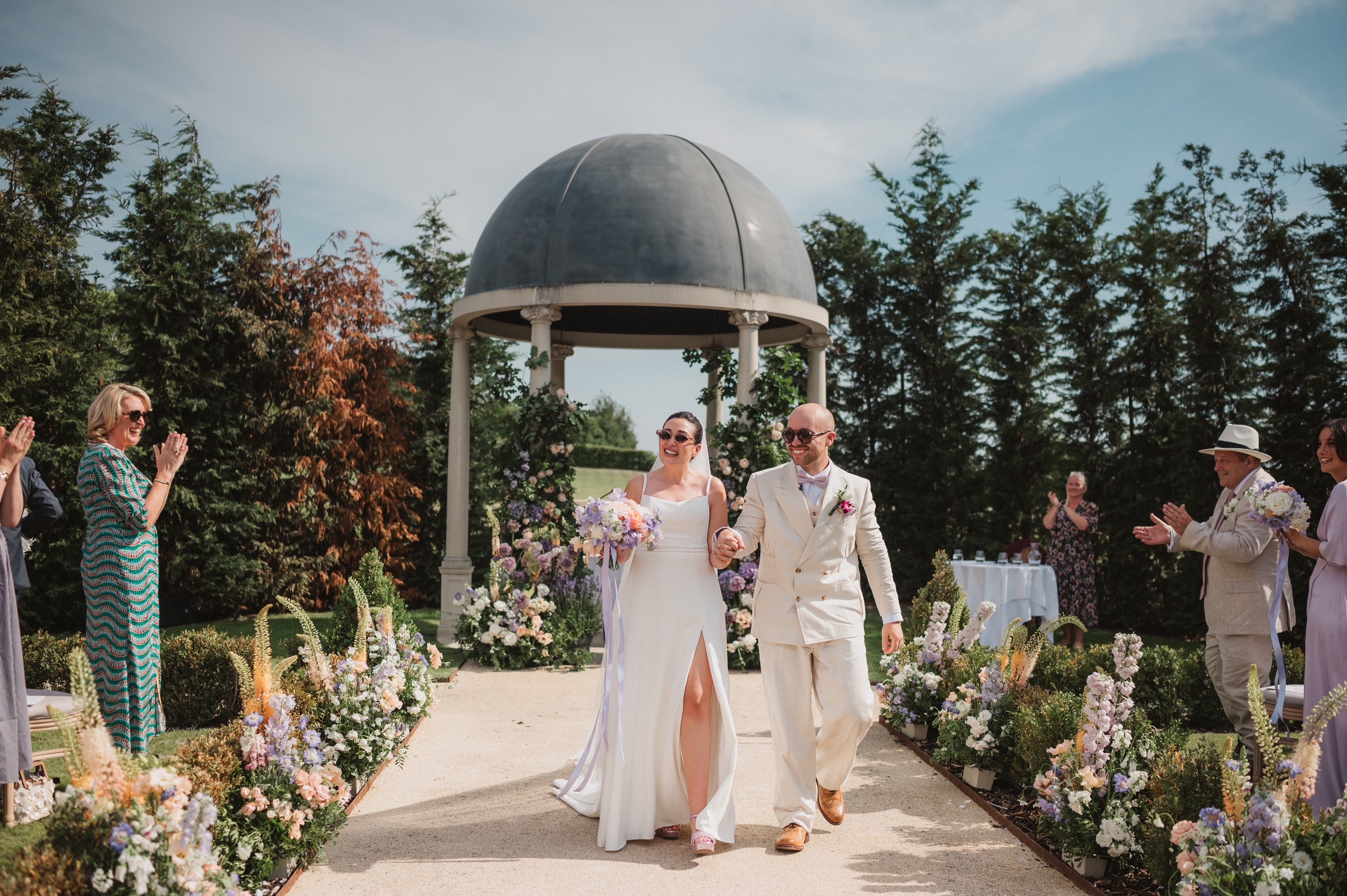 Bride and groom walking away from pavilion after wedding