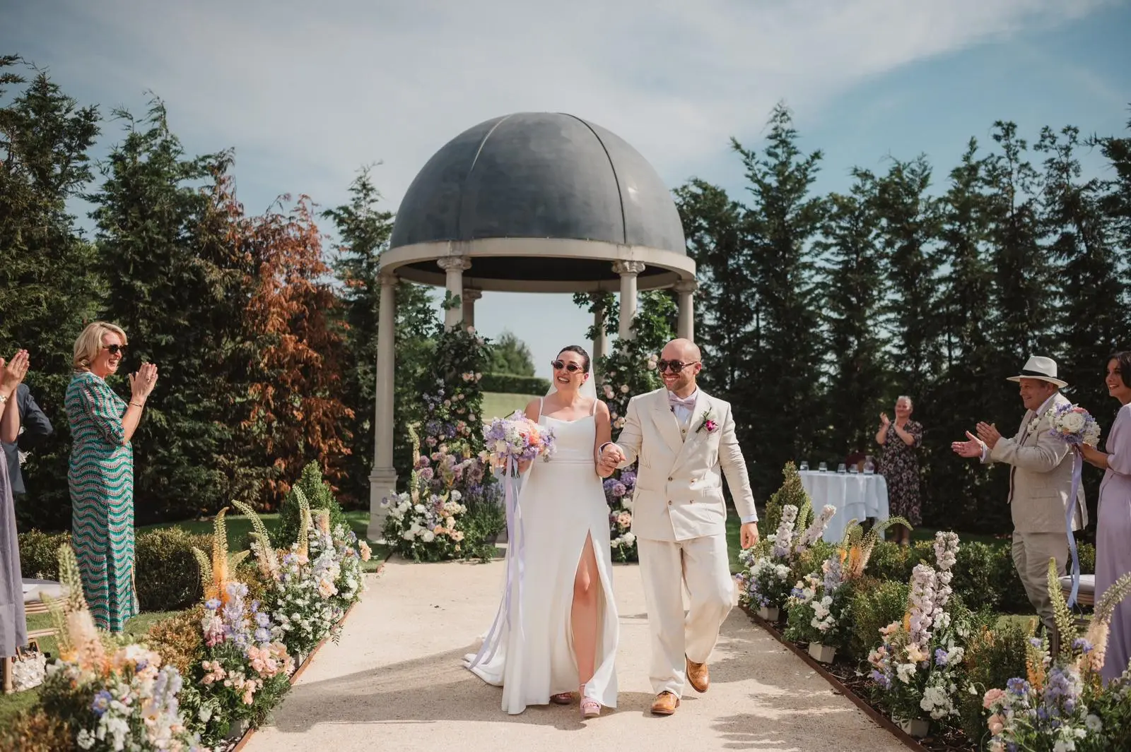 Bride and groom walking away from pavilion after wedding