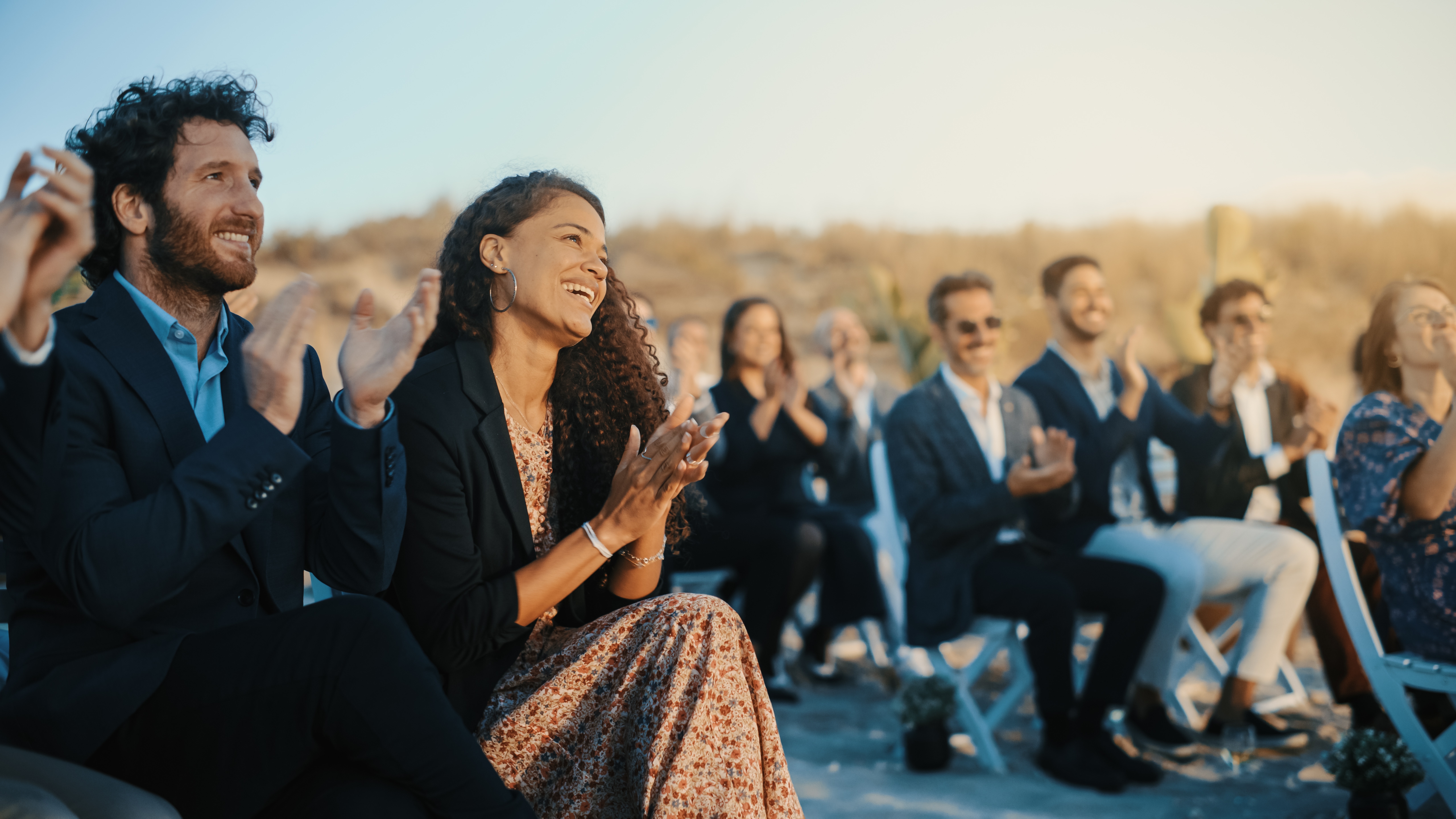 wedding guests looking watching a wedding ceremony smiling and clapping