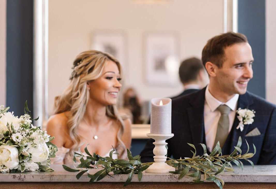 Bride and groom sitting at table at Bury St Edmunds Register Office