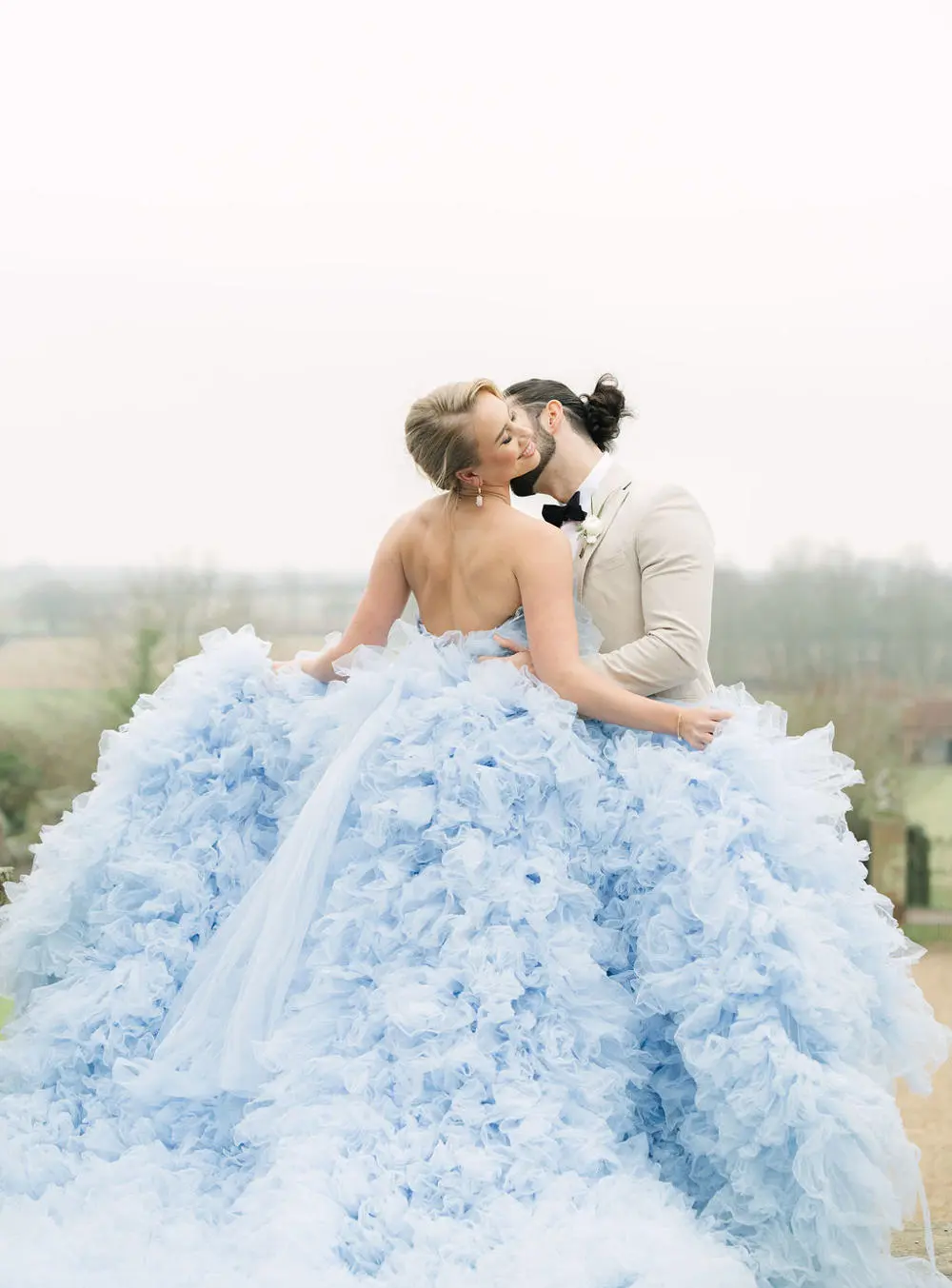 Couple kissing in field bride swooning