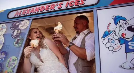 Bride and groom eating ice cream in a van