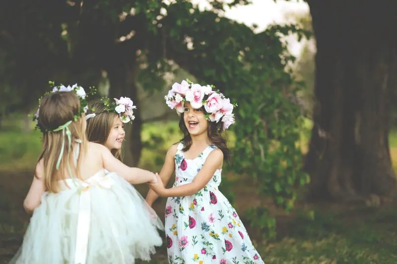 Three girls dancing with flower crowns Little Guest Creche