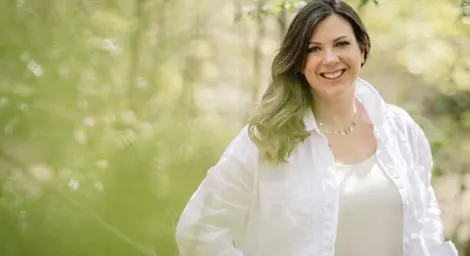 Louisa May Wedding planner smiling in a meadow