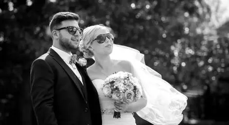 Black and white image of bride and groom with sunglasses