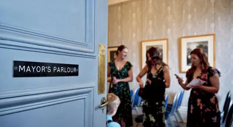 Door into the Mayor's Parlour at Sudbury Register Office with group of bridesmaid waiting for the wedding