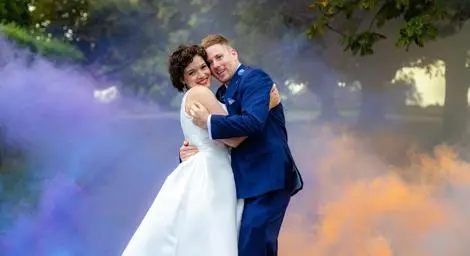 bride and groom hugging in front of flares