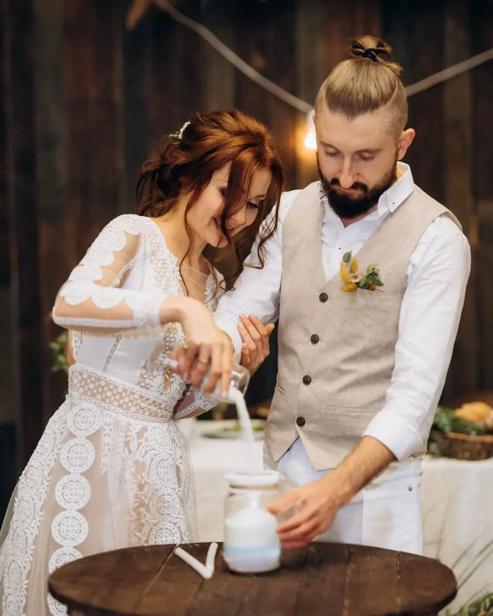 Bride and groom pouring sand into a jar as part of their wedding ceremony