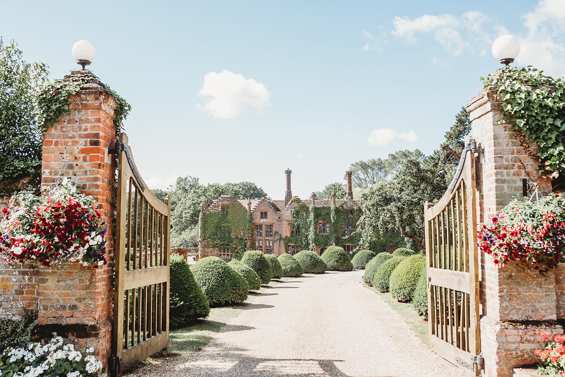 Entrance gate to Seckford Hall gravel drive with shaped topiary 