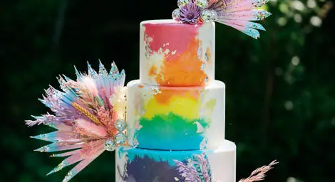 Three tiered wedding cake with rainbow decorations