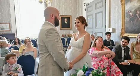 Bride and groom holding hands during their ceremony at Sudbury Town Hall