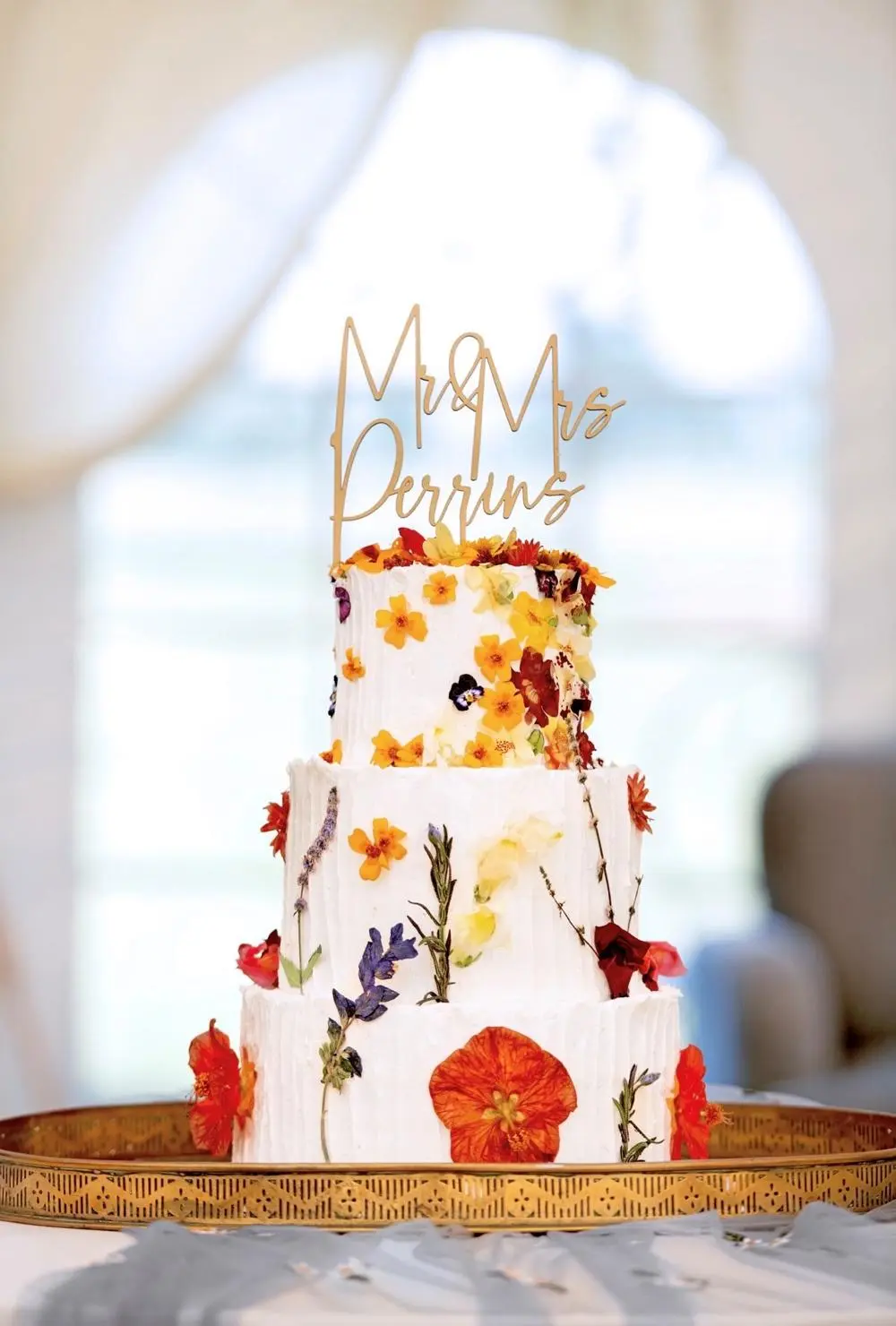 Wedding Cake with three tiers and white icing and flowers dotted all over