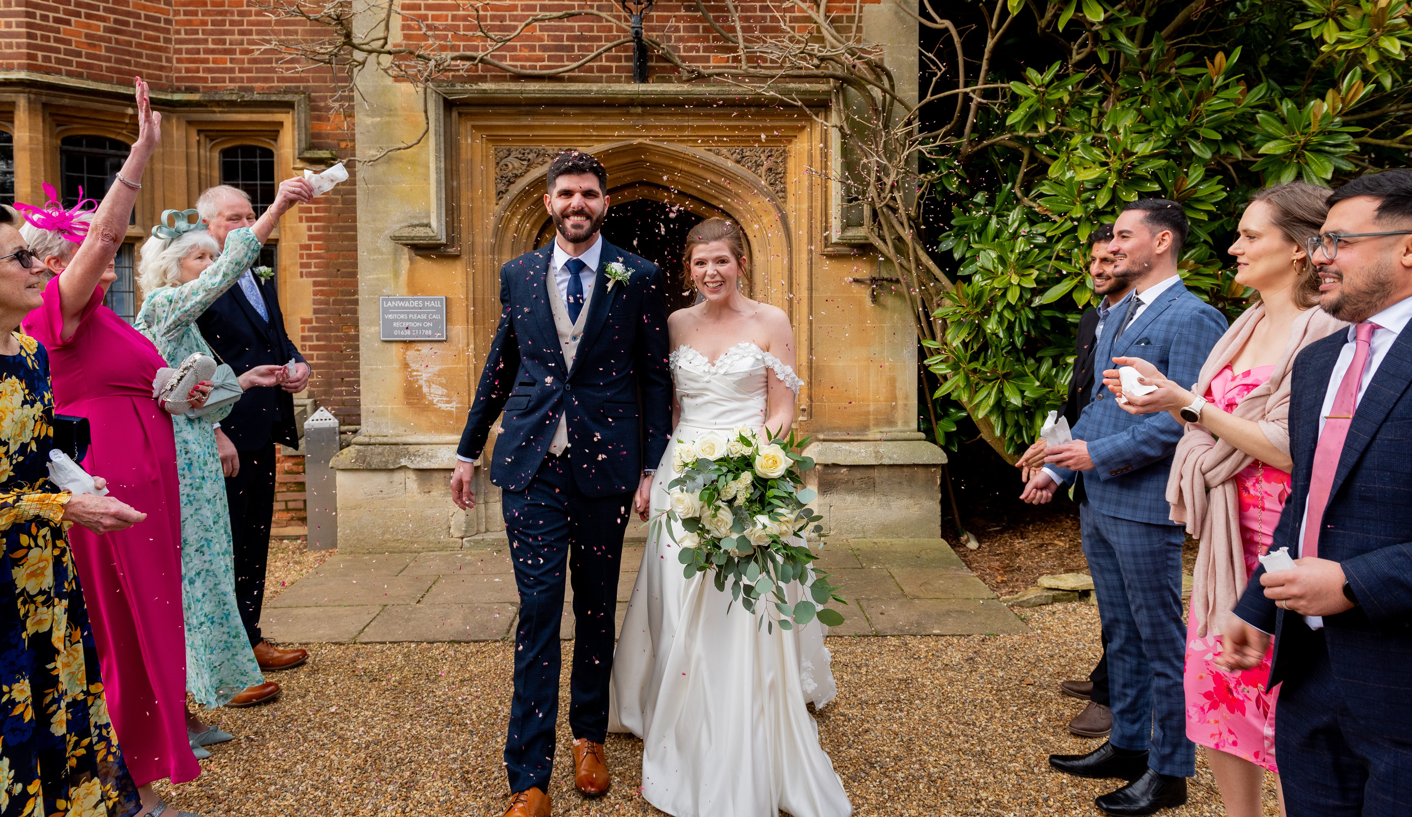 Bride and groom walking through confetti shower