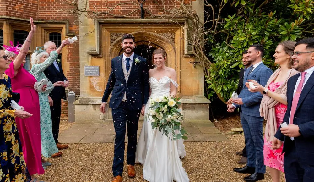 Bride and groom walking through confetti shower