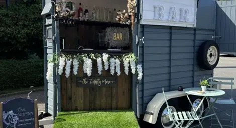 Horsebox bar with green grass like carpet on ramp and flower bunting