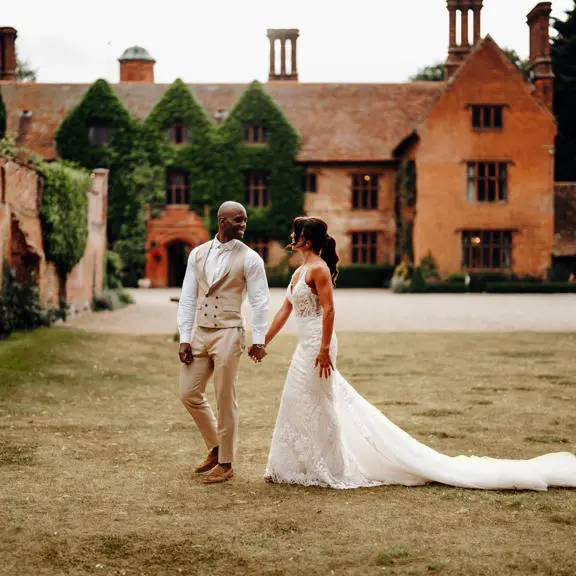 Mixed race couple walking and holding hands while smiling at each other