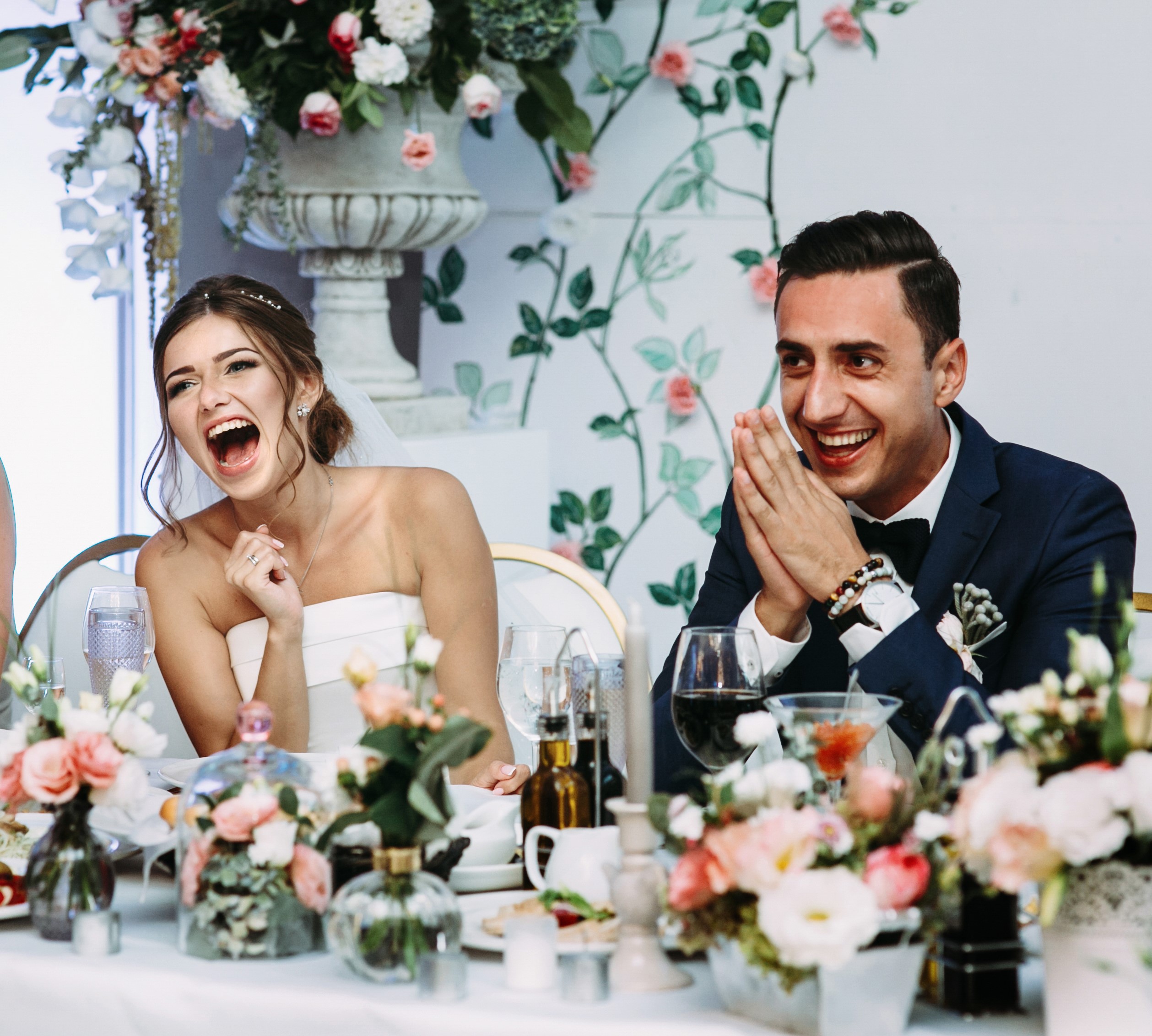 Bride and groom smiling and laughing at their wedding reception.